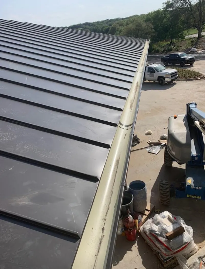 Standing seam panel and gutter detail on a metal roofing jobsite in Ayden